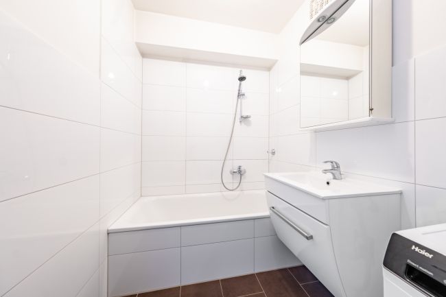 Modernes Bad mit Wanne, hellen Fliesen und gepflegter Ausstattung.